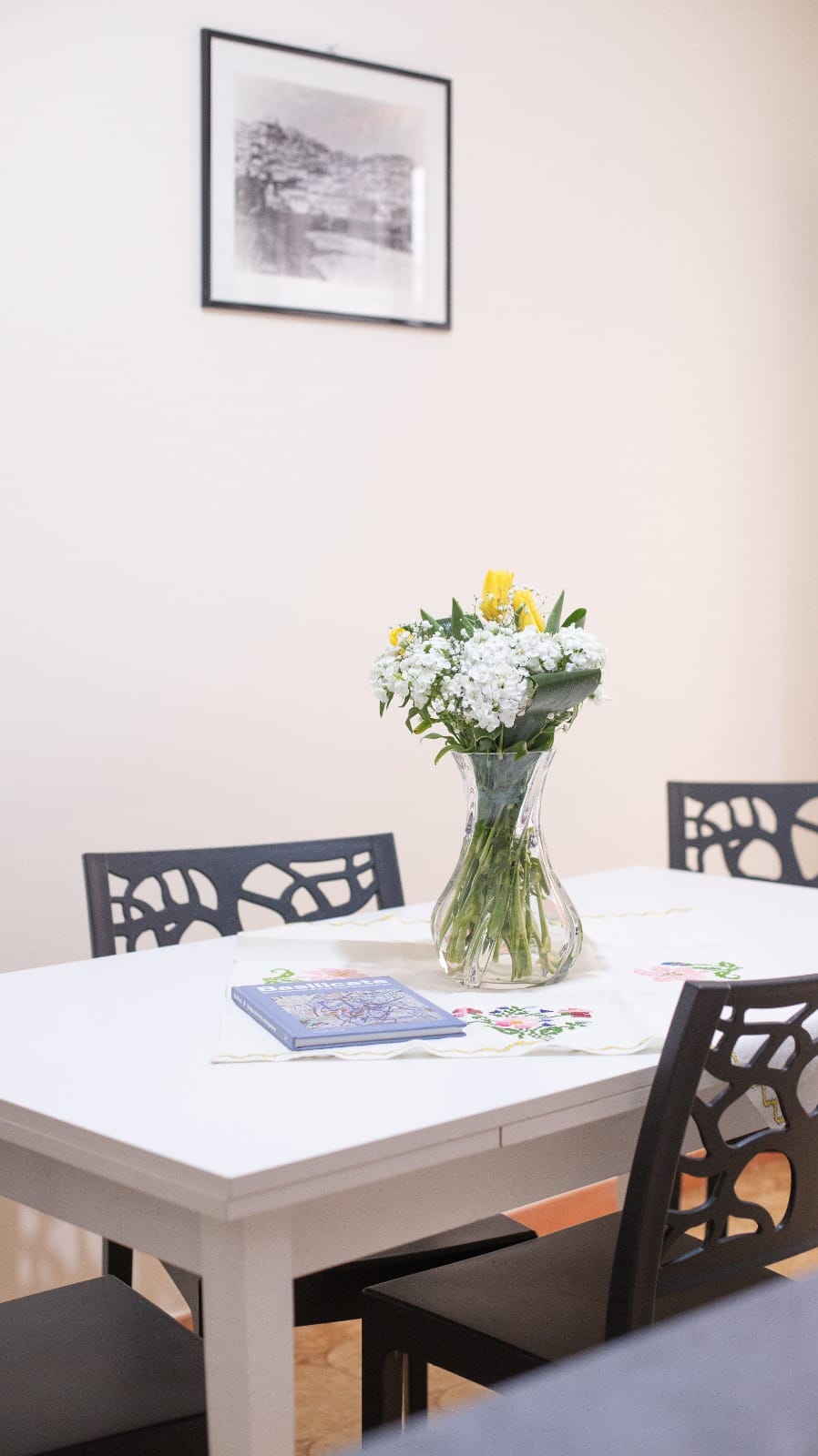 Il tavolo da pranzo apparecchiato con fiori freschi